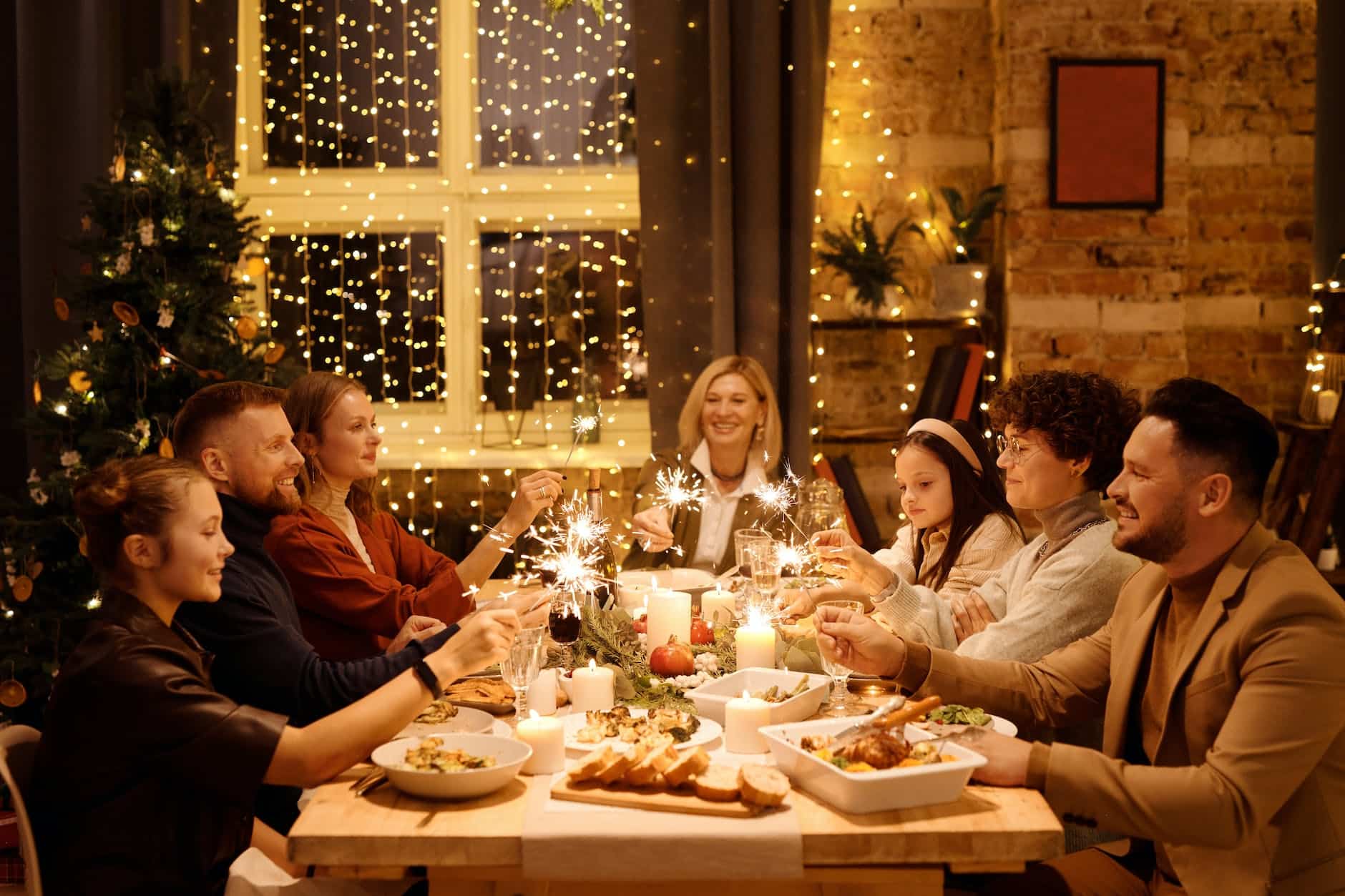 family celebrating christmas while holding burning sparklers