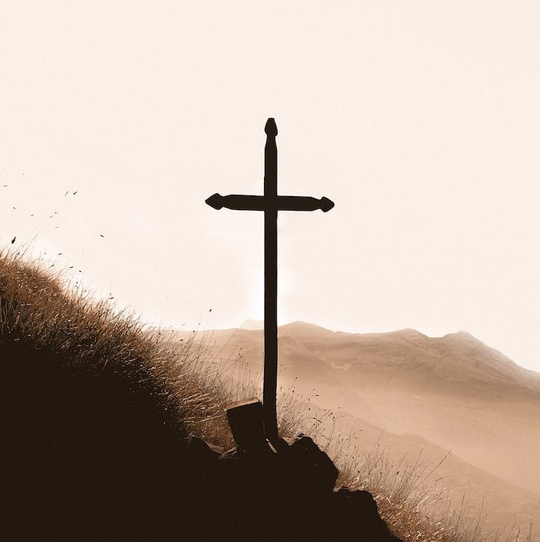 brown wooden cross on mountain during daytime